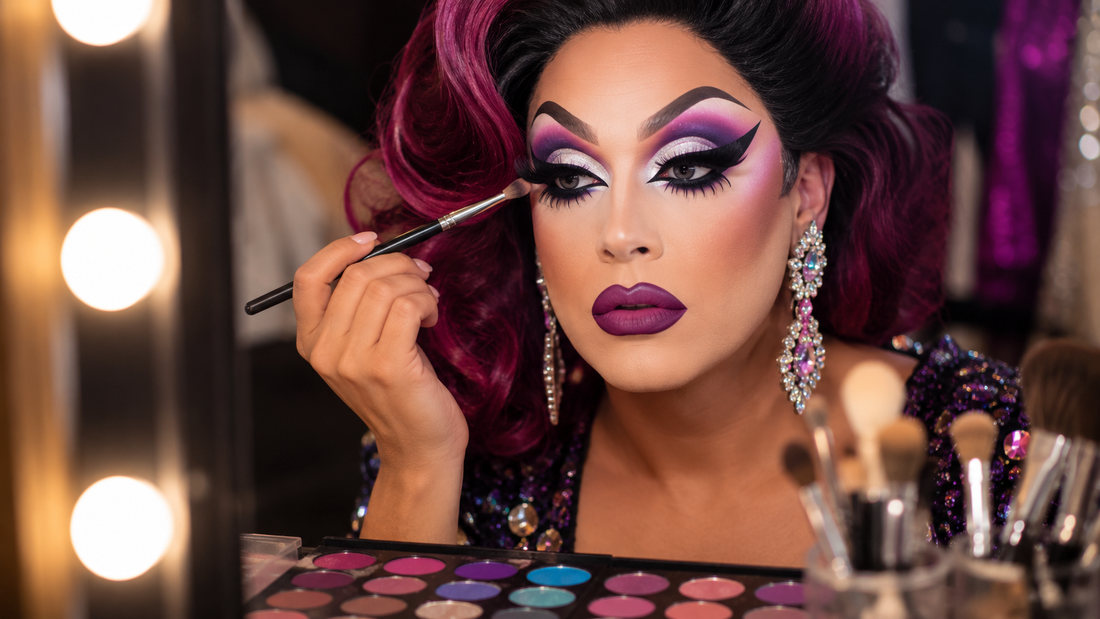 Drag queen con trucco occhi drammatico, ciglia finte, ombretti brillanti e look glamour da scena.